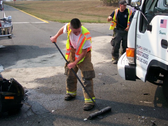 FF/EMT Carlos Mays cleans fluids and debris from roadway