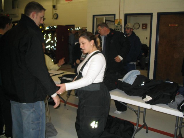 Firefighter/EMT Aimee Cenate gets fitted for her new turnout gear while Jackson looks on