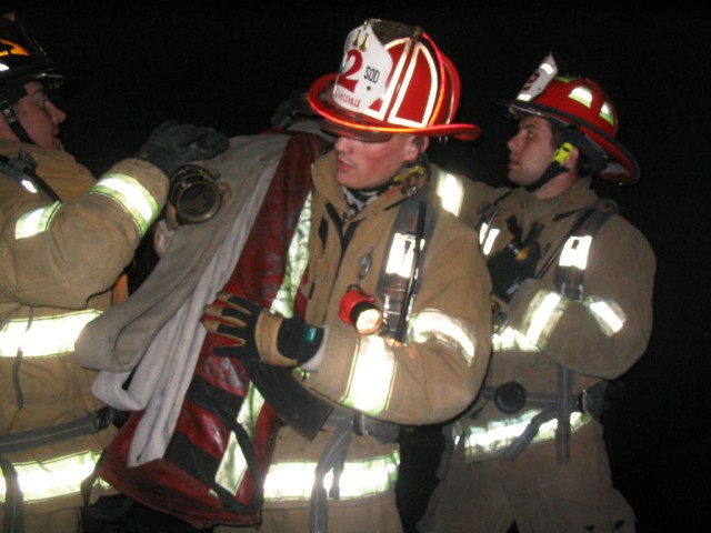 Captain Kurtz, Firefighter Russell and Lieutenant Hemming work the standpipe pack during a drill at the SMRTC in La Plata