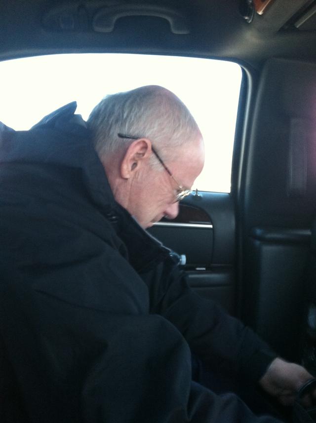 Apparatus Committee Chairman Joe Guyther reads while heading back to the airport from  Pierce Manufacturing