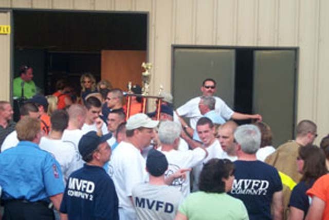 Chief Raley and President Colonna hold the &quot;Best Appearing Company Overall&quot; trophy after receiving it at the So. Md. Convention in Hollywood while other members gather around.