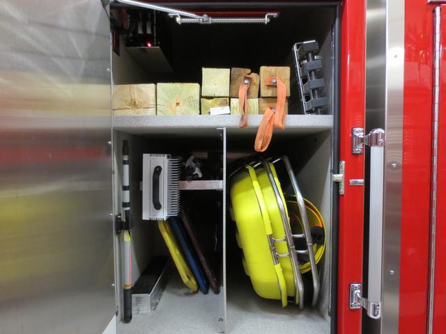 Transverse cab compartment houses both stokes baskets, tripod lights, back boards, brooms, officers halligan bar, long timbers, long hooks and the Little Giant Ladder platform